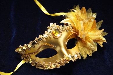 Photo of Theater arts. Golden venetian carnival mask on blue fabric