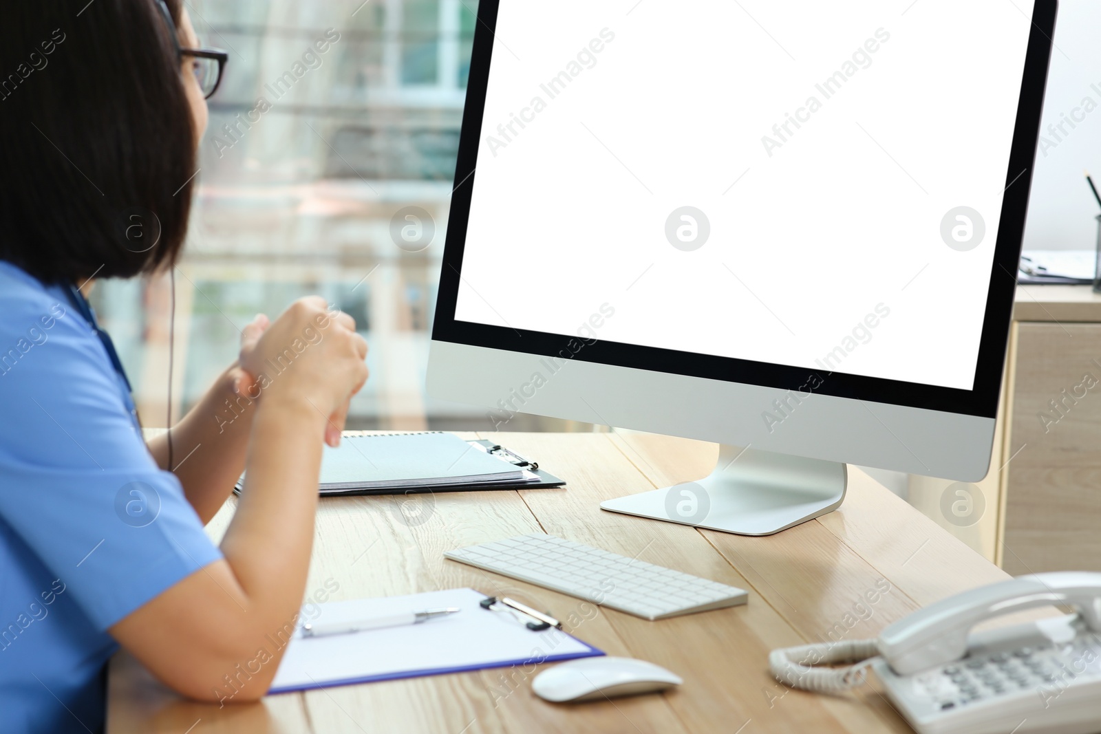 Photo of Doctor working with computer at table in office. Hotline service