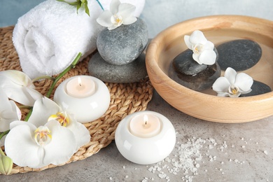 Photo of Composition with spa stones and candles on gray table