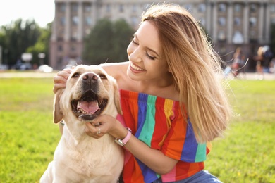 Photo of Cute yellow labrador retriever with owner outdoors