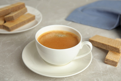 Delicious coffee and wafers for breakfast on grey marble table