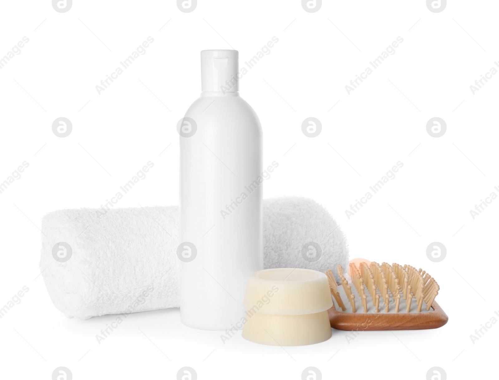 Photo of Solid shampoo bars, bottle of cosmetic product and wooden brush on white background