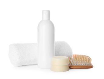 Solid shampoo bars, bottle of cosmetic product and wooden brush on white background