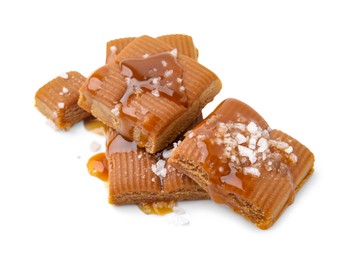 Photo of Yummy caramel candies and sea salt isolated on white