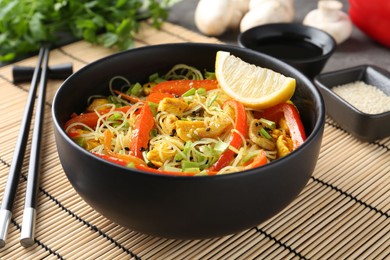 Photo of Stir-fry. Delicious cooked noodles with chicken and vegetables in bowl served on table, closeup