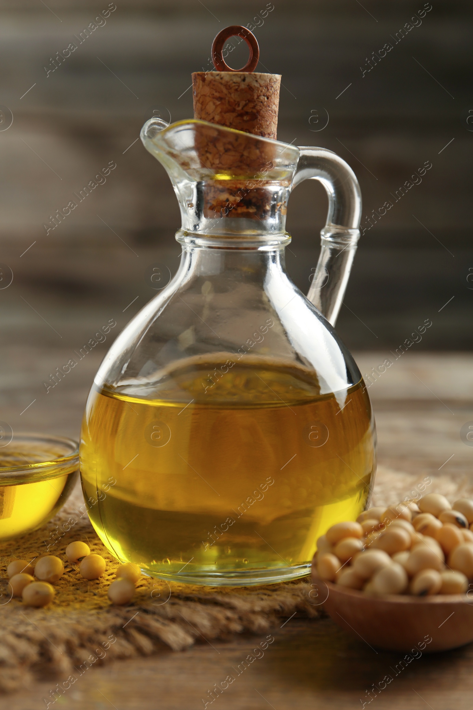 Photo of Composition with soybean oil on wooden table, closeup