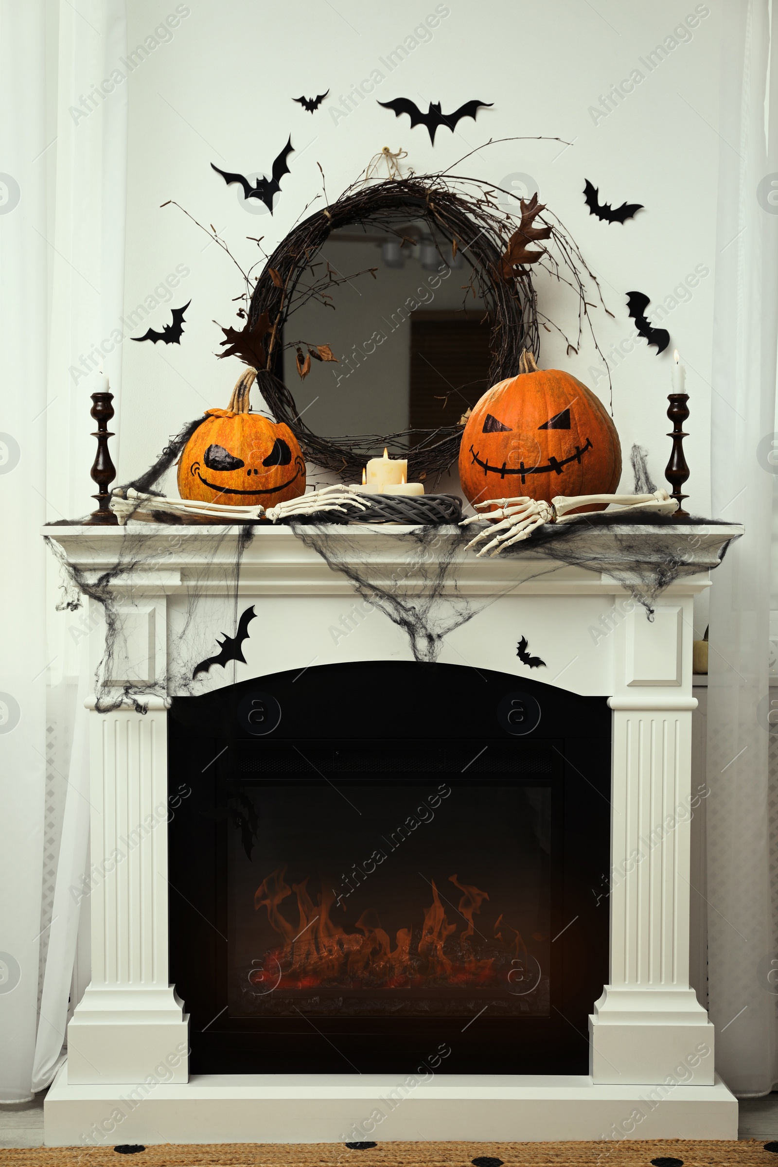 Photo of Different Halloween decor on mantelpiece indoors. Festive interior