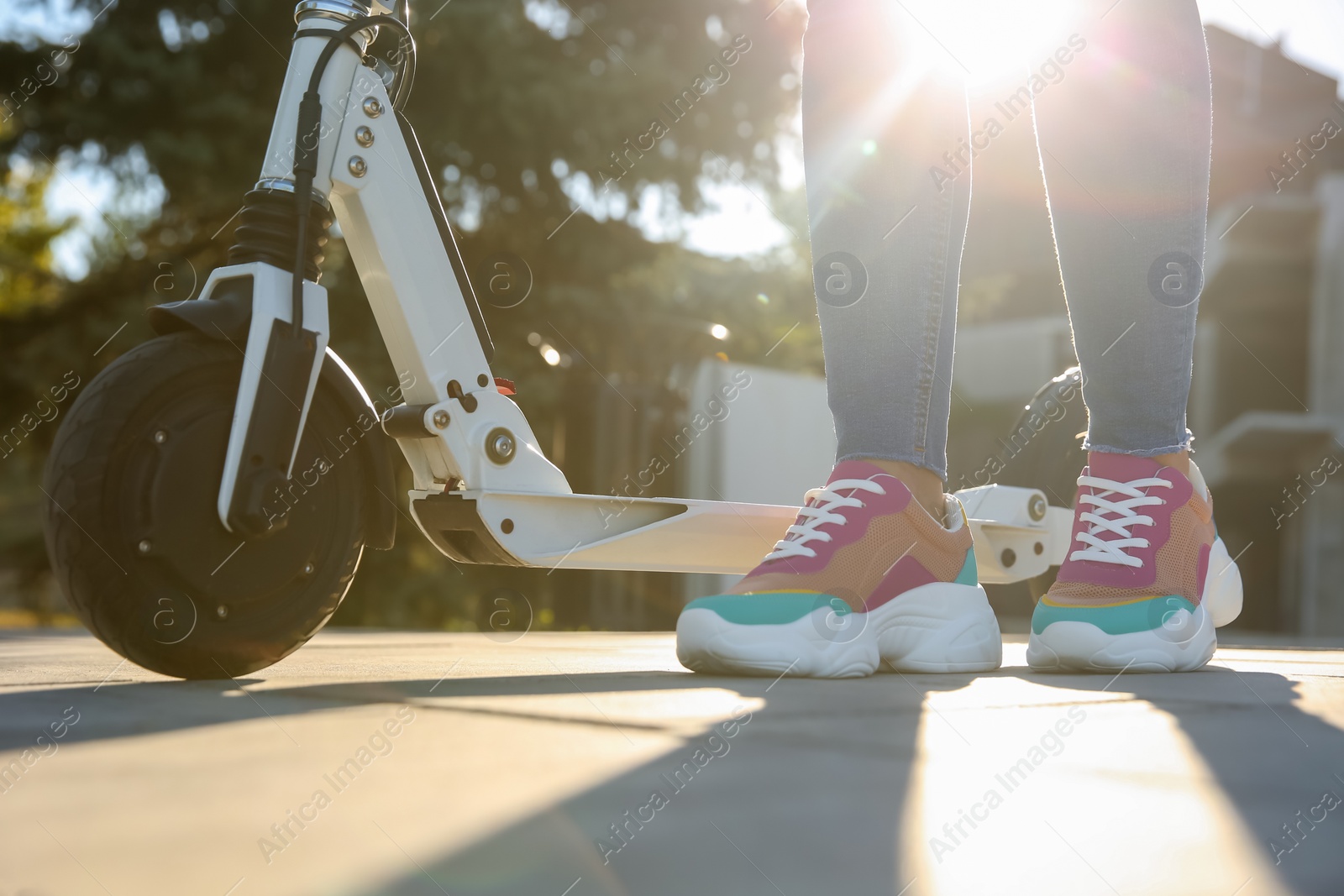 Photo of Woman with electric kick scooter outdoors, closeup