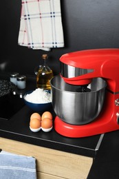 Photo of Modern stand mixer and ingredients on countertop in kitchen. Home appliance