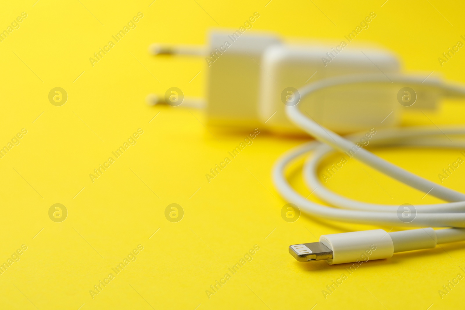 Photo of USB charger on yellow background, closeup. Space for text