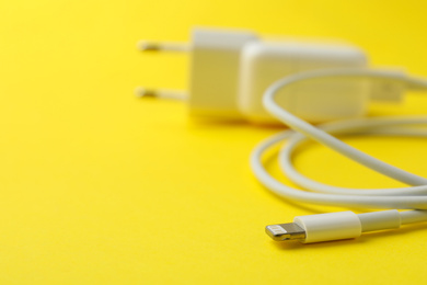 Photo of USB charger on yellow background, closeup. Space for text