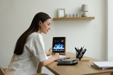 Photo of Businesswoman working with tablet in office. Forex trading
