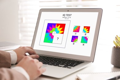 Image of Woman using laptop for taking IQ test indoors, closeup