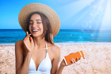 Young woman applying sun protection cream at beach