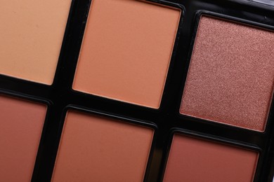 Colorful contouring palette as background, closeup. Professional cosmetic product