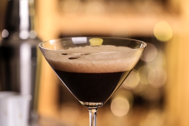Glass of delicious Espresso Martini on blurred background. Alcohol cocktail