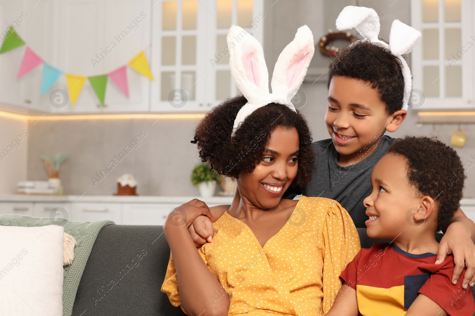 Photo of Happy African American mother and her cute children in kitchen