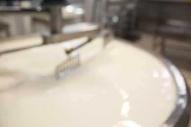 Blurred view of curd preparation tank with milk at cheese factory