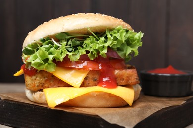 Photo of Delicious tofu burger served with sauce on board, closeup