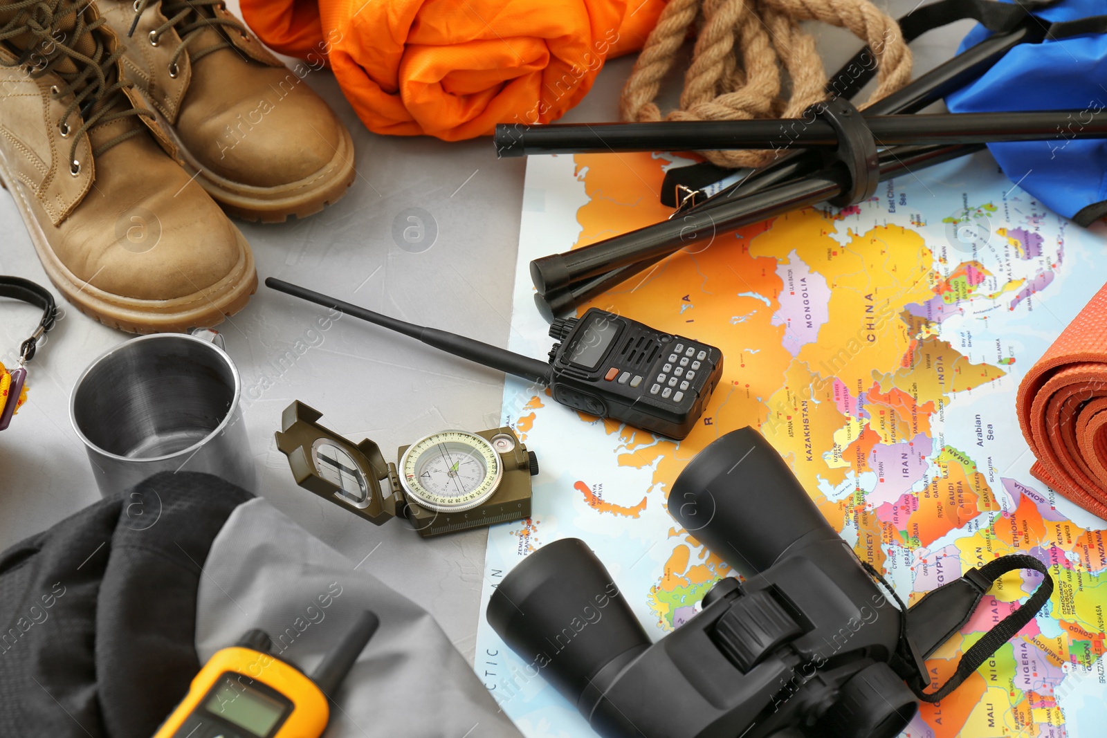 Photo of Set of camping equipment with sleeping bag on grey background