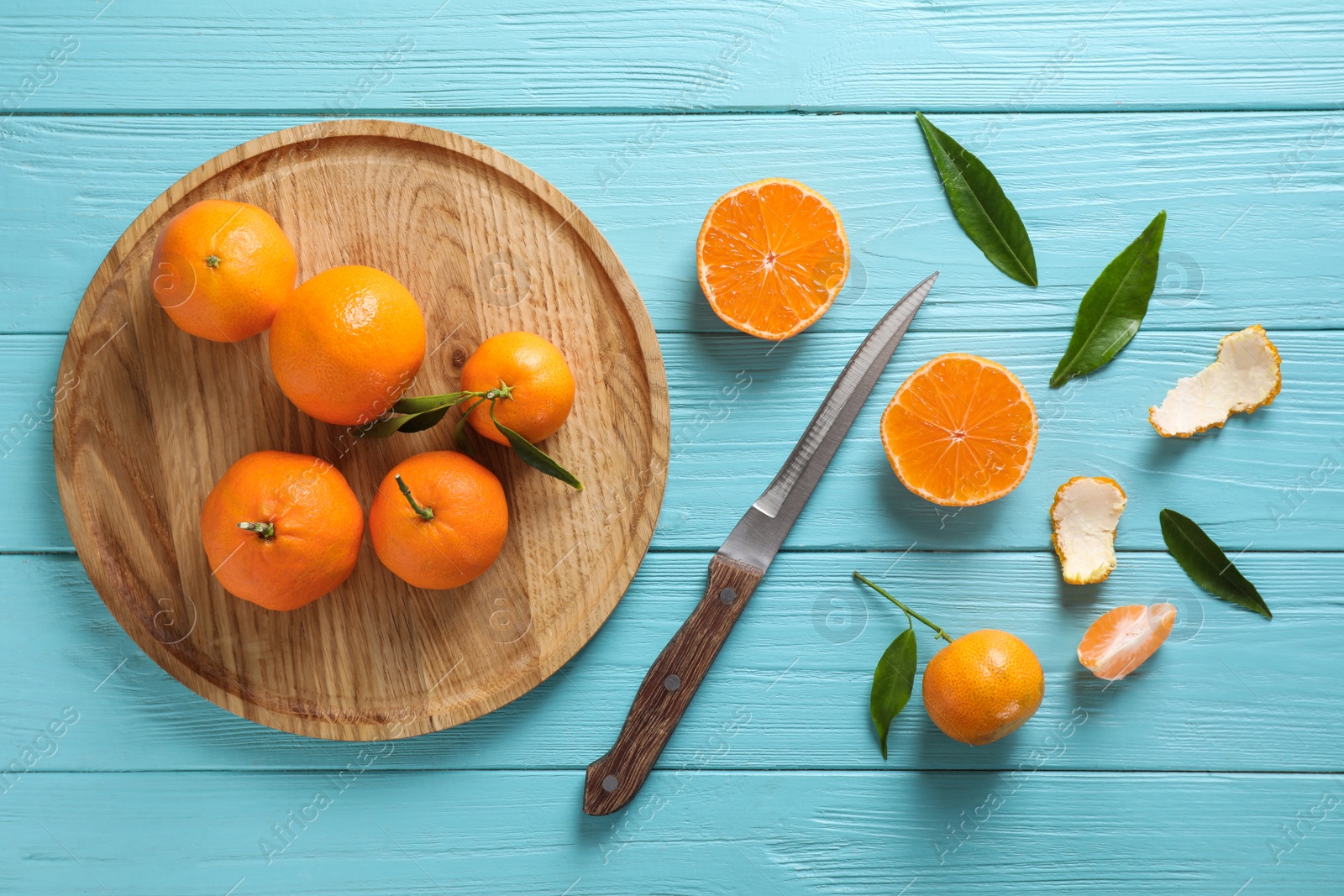 Photo of Fresh ripe tangerines on light blue wooden table, flat lay