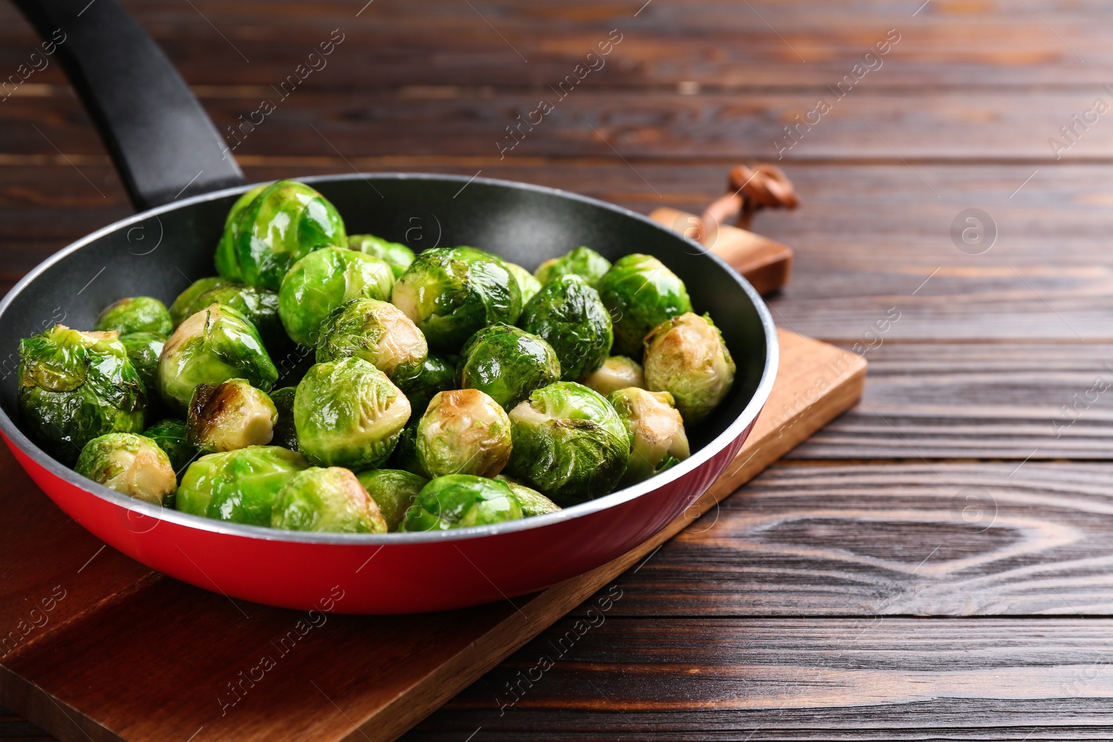 Photo of Roasted Brussels sprouts in frying pan on wooden table