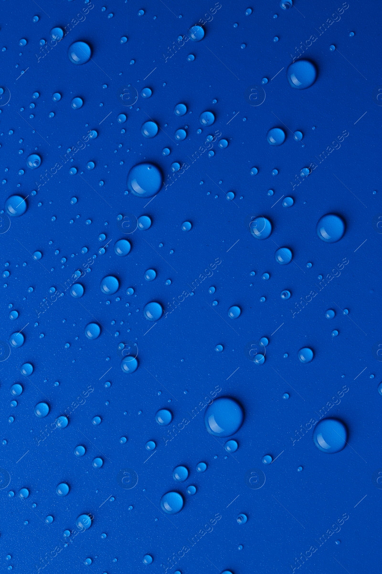 Photo of Water drops on blue background, top view