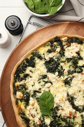 Delicious homemade spinach quiche on white table, flat lay