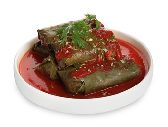 Photo of Plate of delicious stuffed grape leaves with tomato sauce and parsley isolated on white