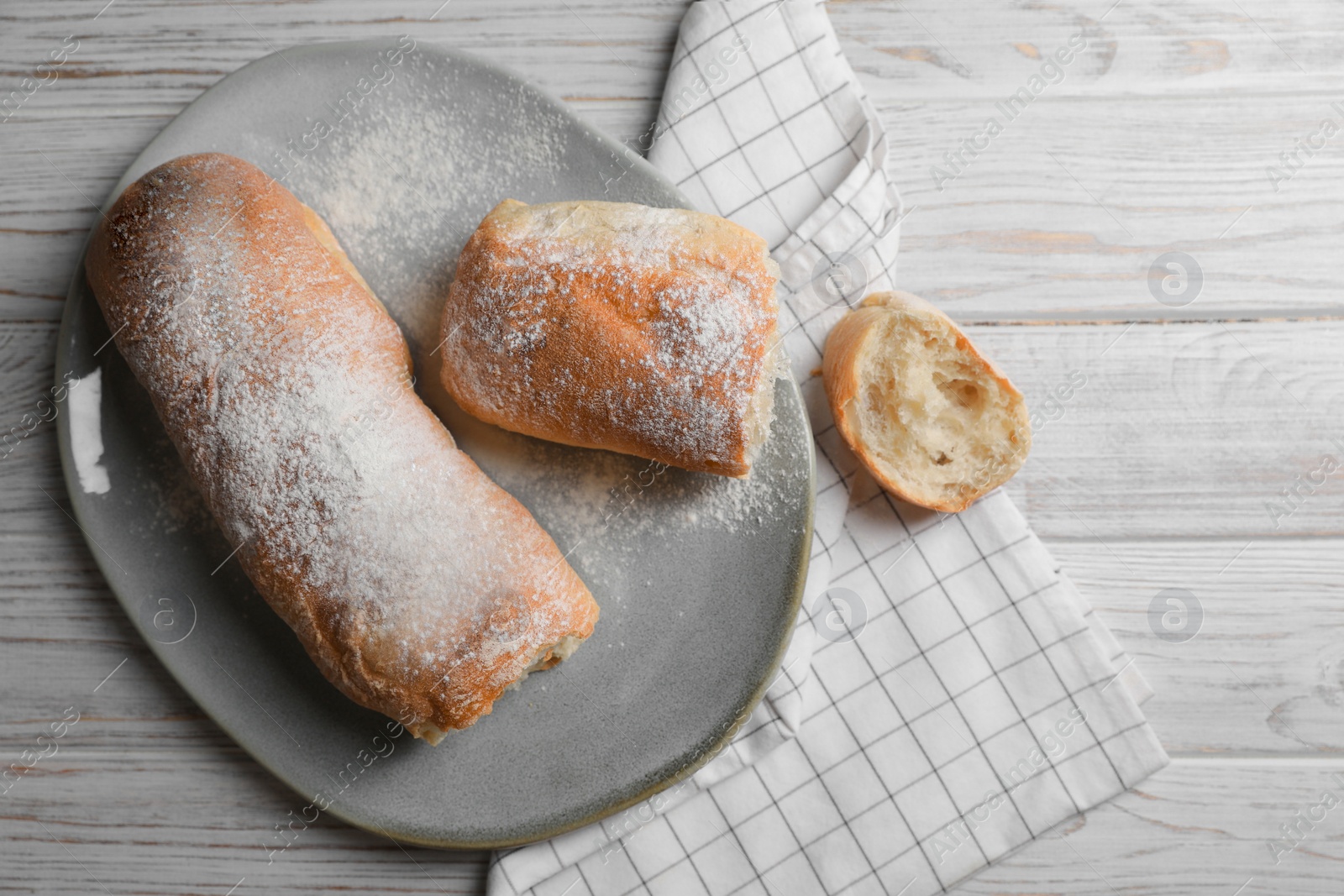 Photo of Fresh crispy ciabattas on white wooden table, flat lay