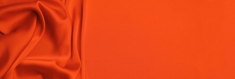 Image of Orange silk fabric as background, top view with space for text. Banner design