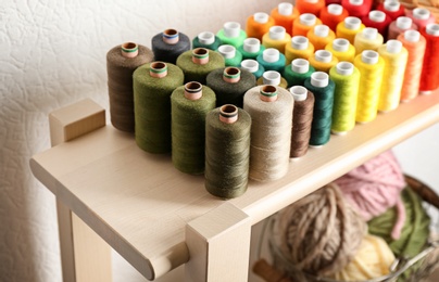 Set of color sewing threads on wooden shelf