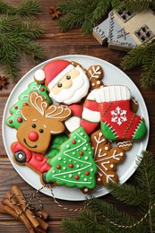 Photo of Different tasty Christmas cookies and festive decor on wooden table, flat lay