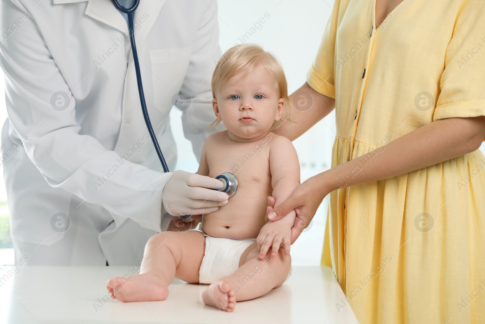 Photo of Pediatrician examining baby with stethoscope in hospital. Health care