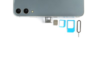SIM card, mobile phone and ejector on white table, flat lay