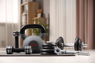 Many different sports equipment on floor indoors