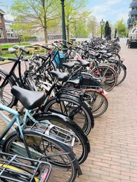 Photo of Many different bicycles parked on sidewalk, closeup