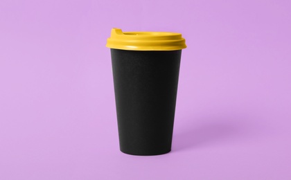 Takeaway paper coffee cup on violet background