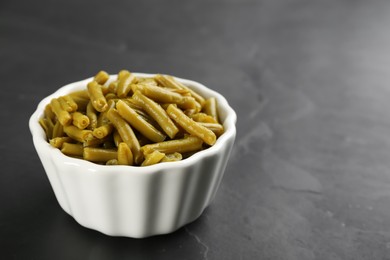 Canned green beans on black table. Space for text