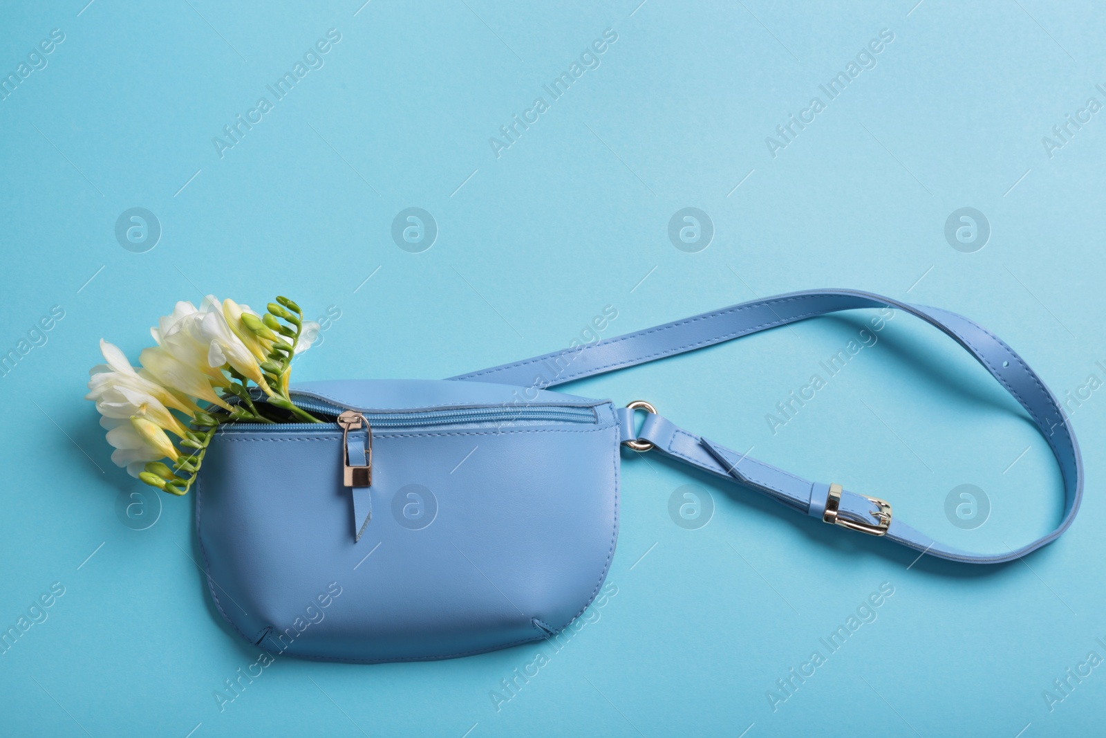 Photo of Flat lay composition with stylish woman's handbag and spring flowers on color background