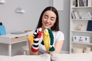 Photo of Happy woman performing puppet show at home