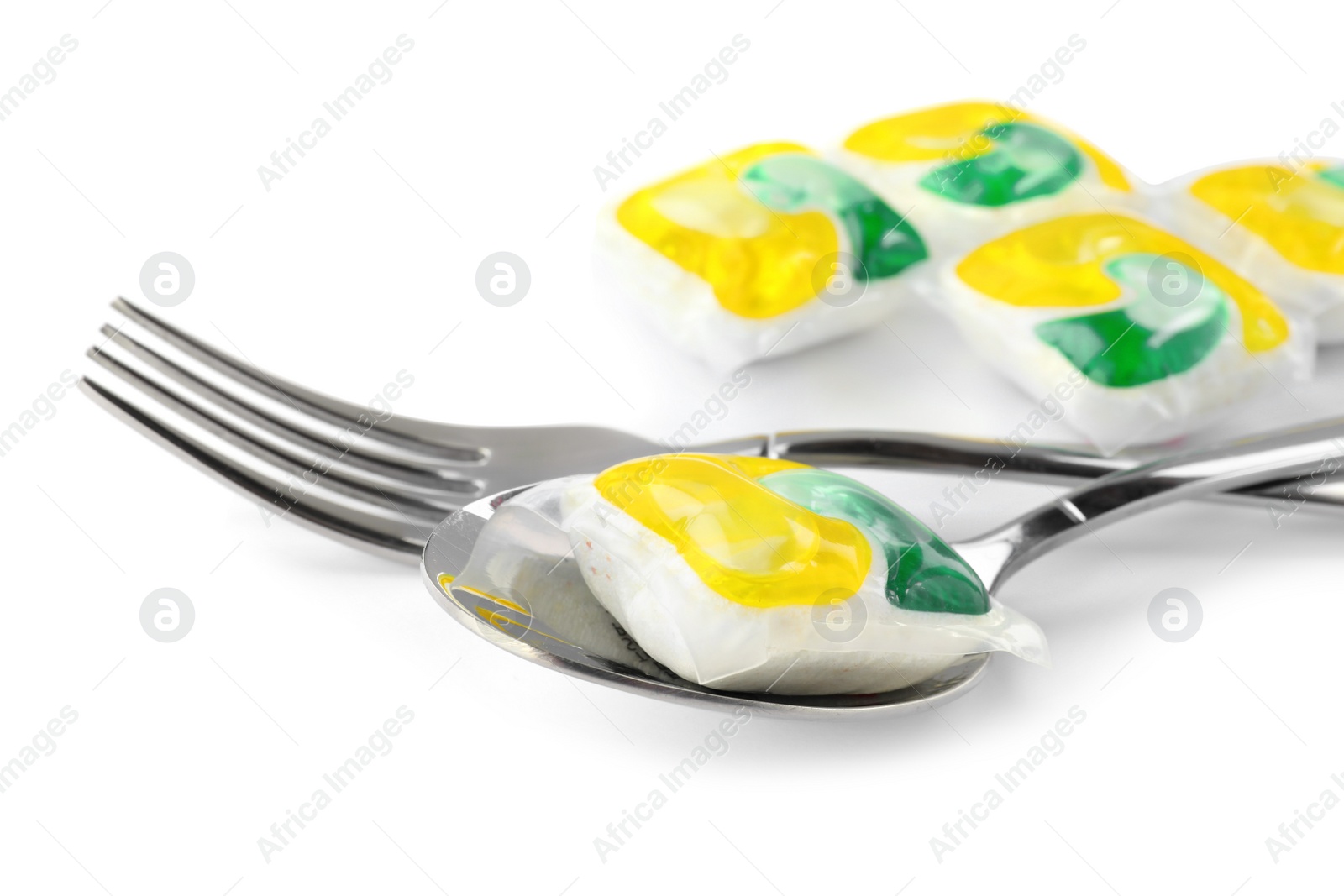 Photo of Cutlery with many dishwasher detergent pods on white background