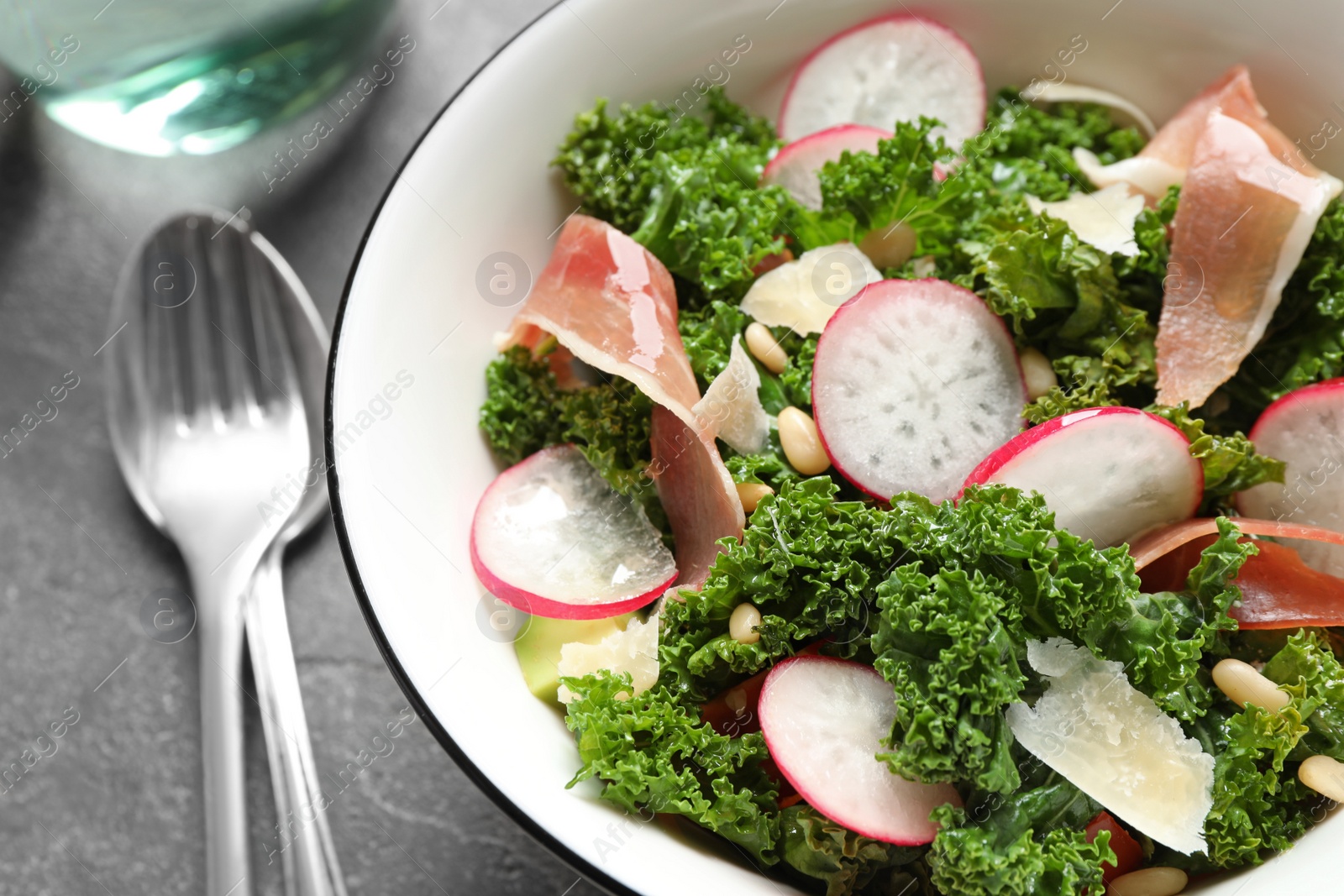 Photo of Tasty fresh kale salad on grey table, closeup