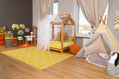 Stylish child room interior with comfortable house bed and play tent