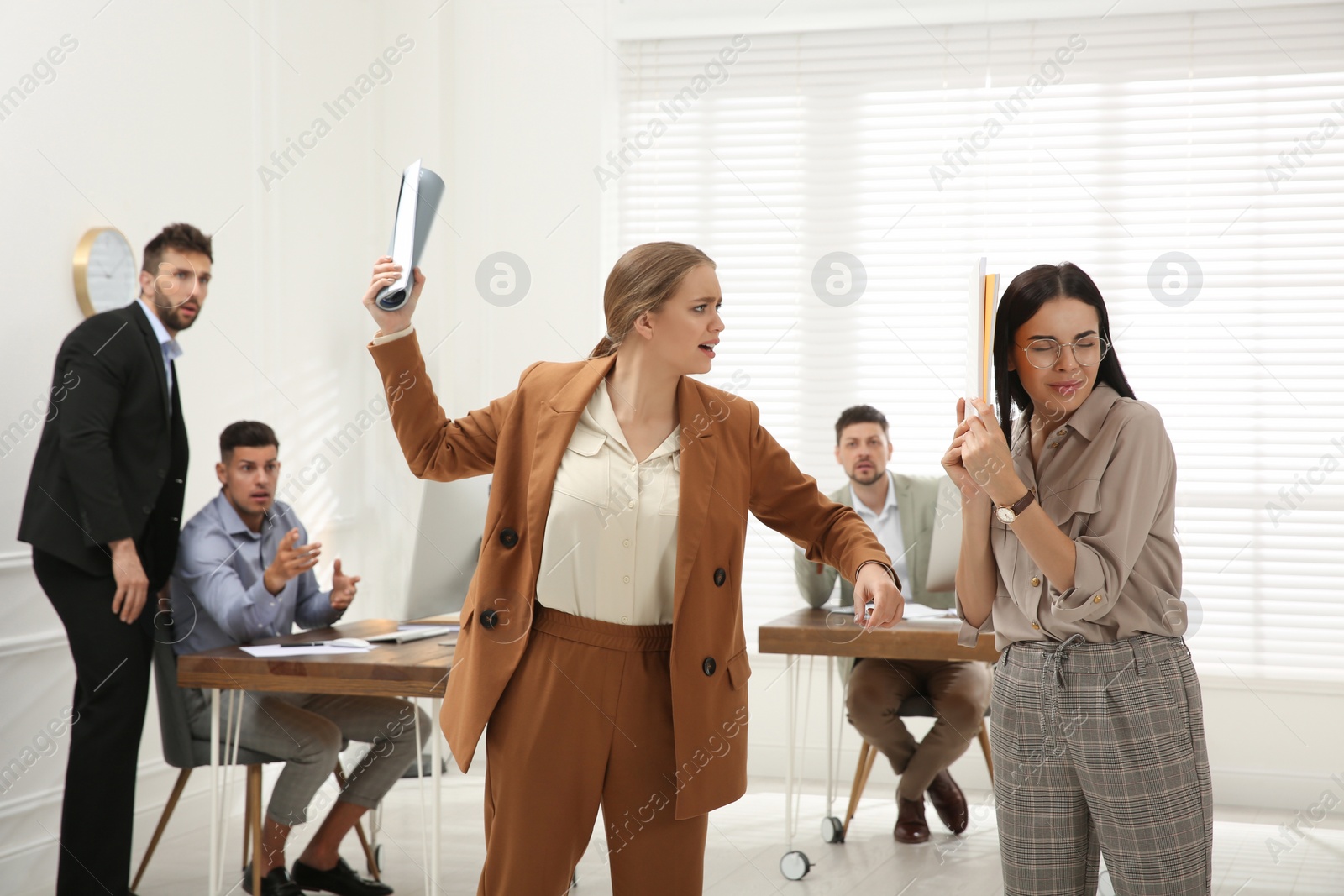 Photo of Emotional colleagues fighting in office. Workplace conflict