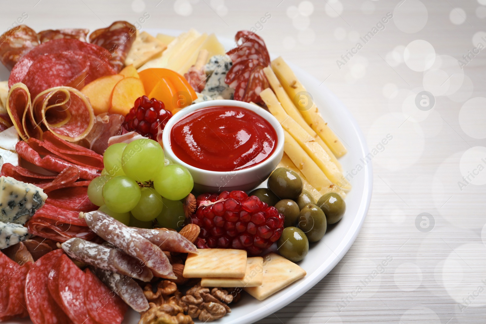 Photo of Plate of different appetizers with dip sauce on white wooden table, closeup. Bokeh effect