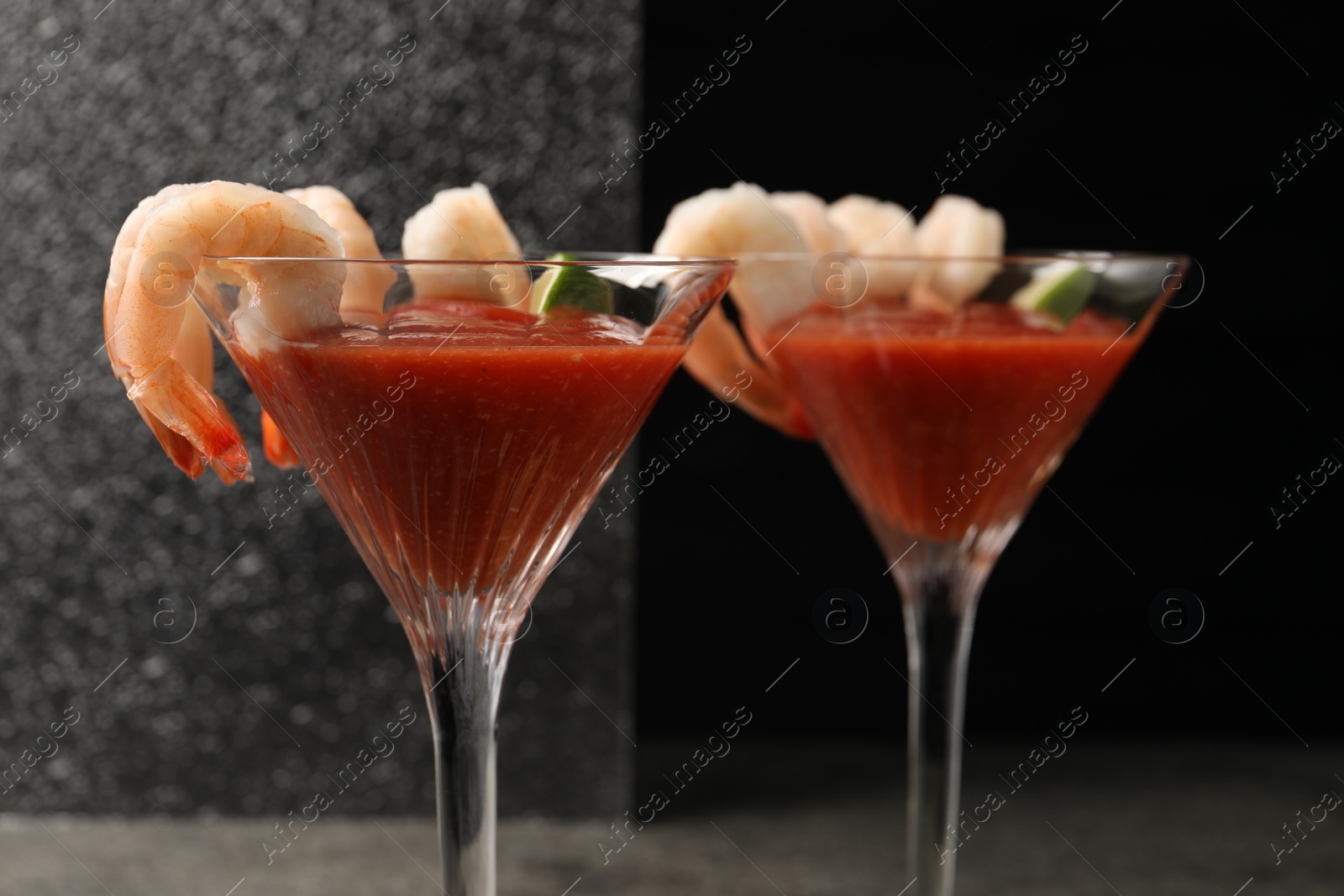 Photo of Tasty shrimp cocktail with sauce in glasses on table, closeup