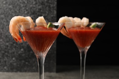 Photo of Tasty shrimp cocktail with sauce in glasses on table, closeup