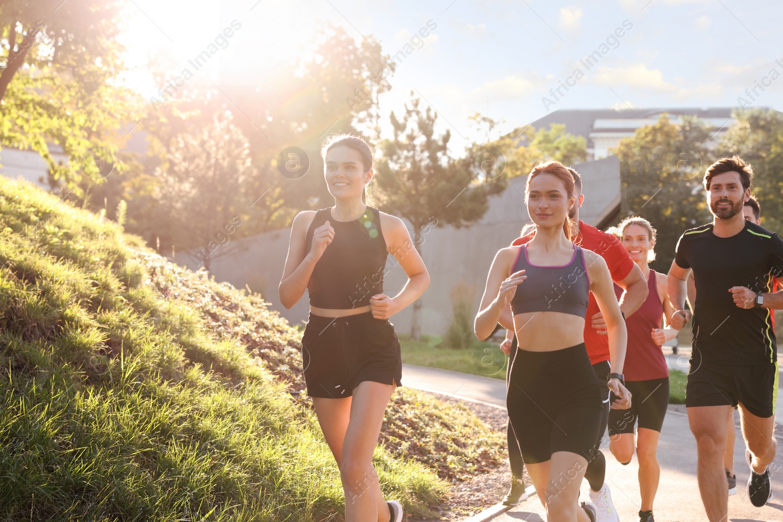 Photo of Group of people running outdoors on sunny day