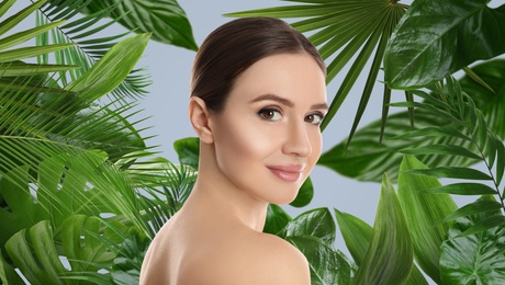 Image of Beautiful young woman and tropical leaves, banner design. Spa portrait